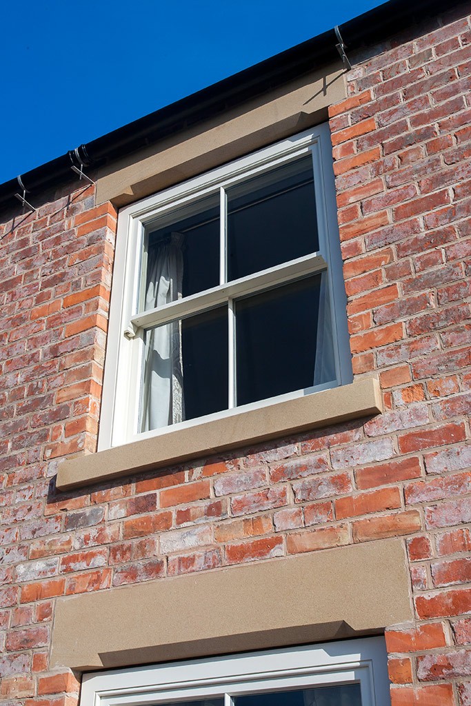 Natural Sand Stone lintol and cill compliment this sliding sash window by Parkwood
